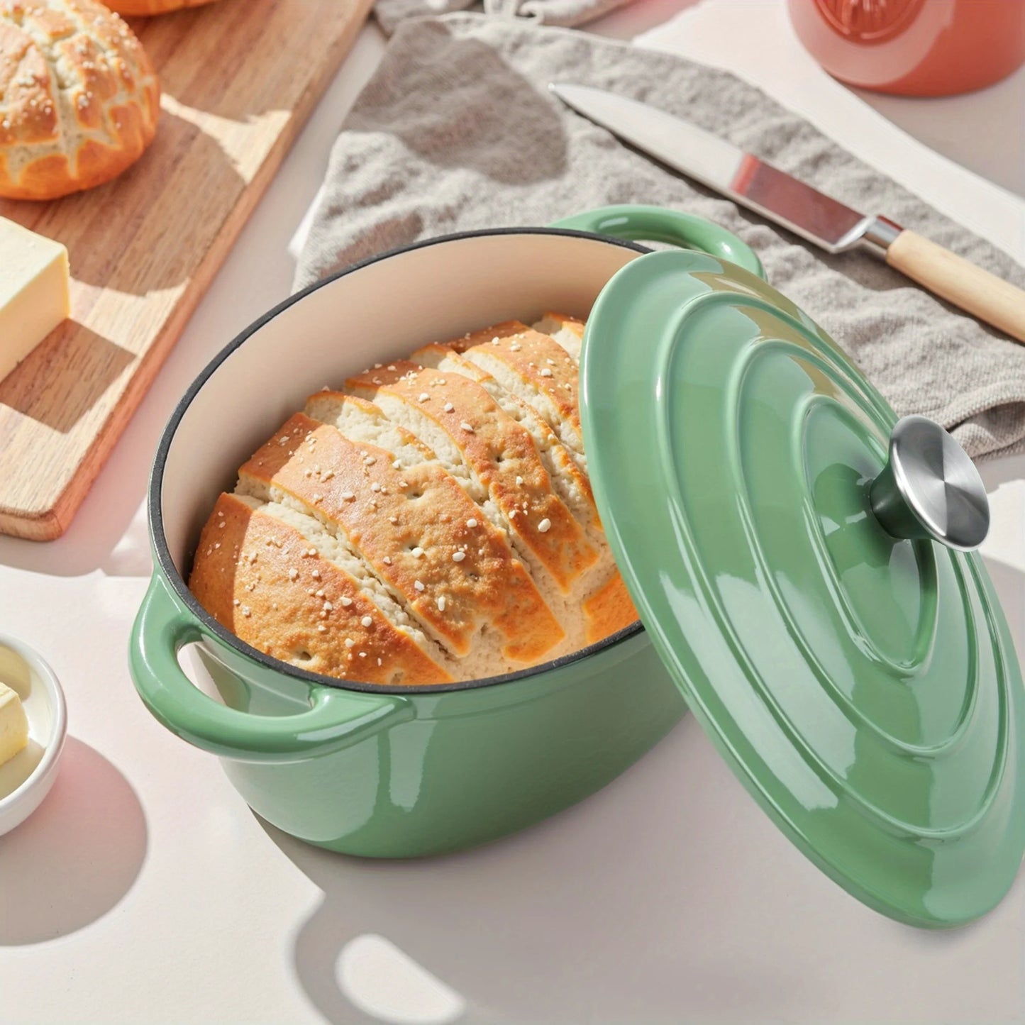 A porcelain-coated cast iron stew pot with a lid and two-handled design, suitable for bread baking and cooking.